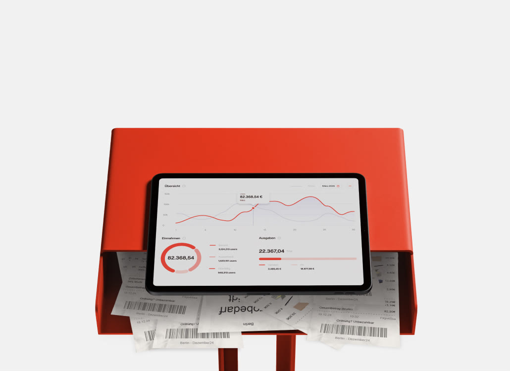 Tablet mit Finanzdashboard auf rotem Tisch